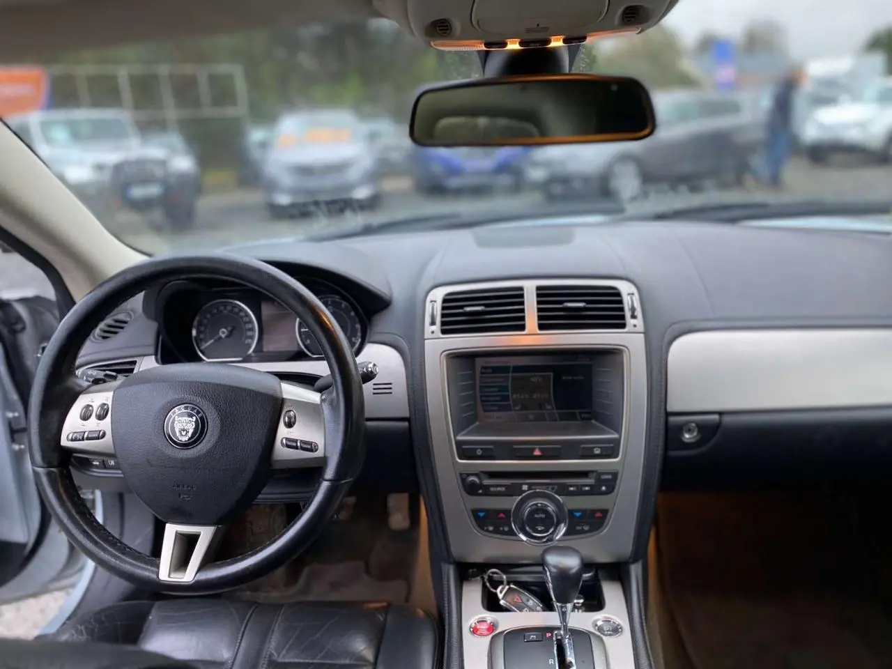 Intérieur du Jaguar XK 2009, vue du tableau de bord et volant en cuir noir avec console centrale et levier de vitesse automatique.