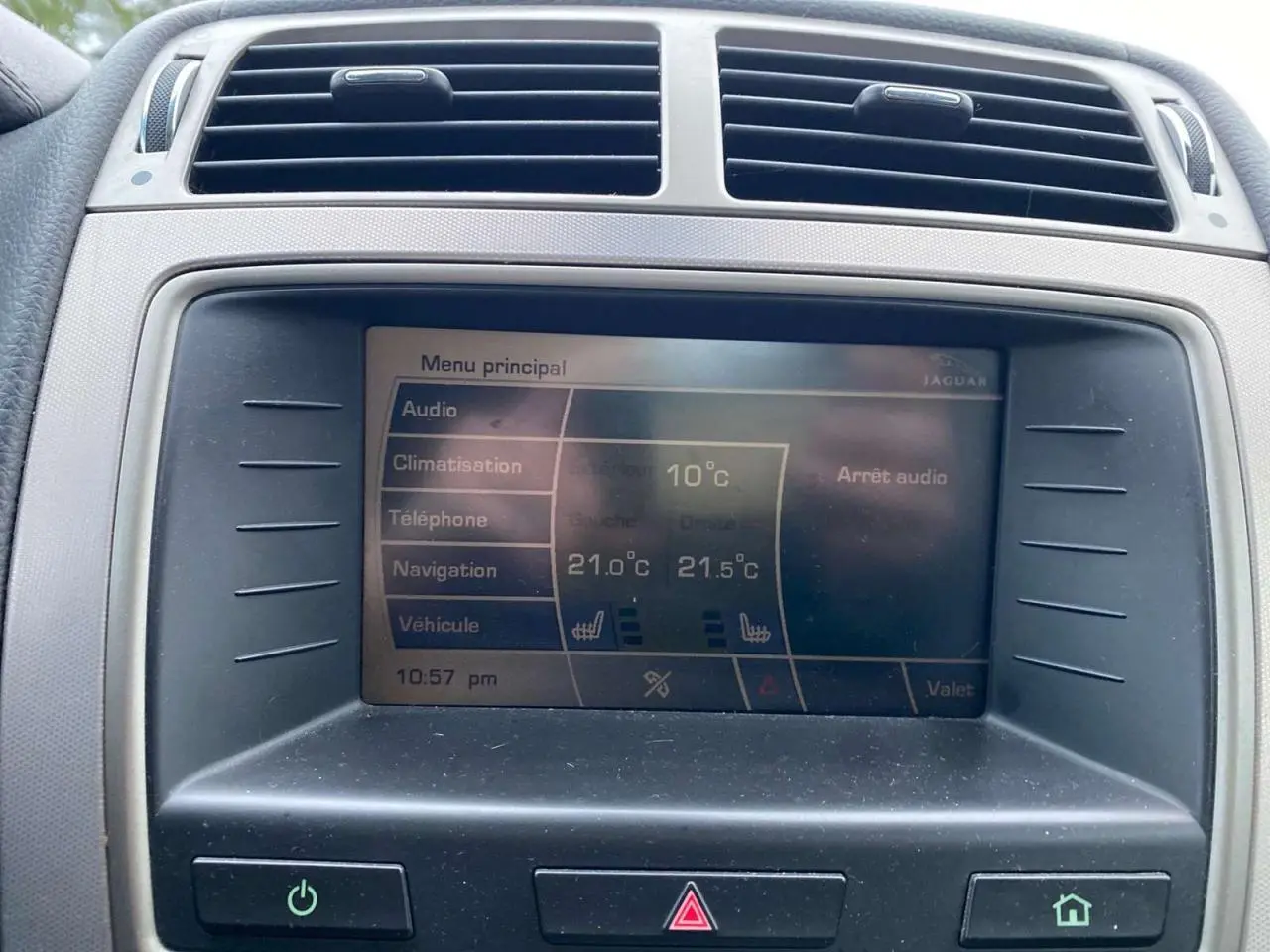 Écran central de la Jaguar XK 2009 gris clair montrant le menu principal avec climatisation et audio.
