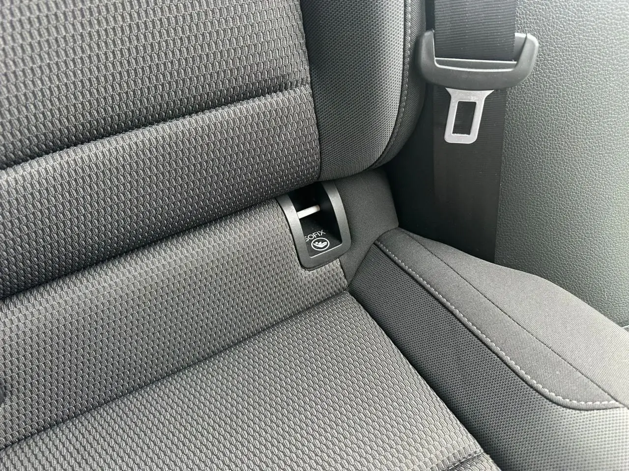 Gros plan sur l'assise arrière noire de la Volkswagen Golf VII avec fixation ISOFIX et ceinture de sécurité visible.