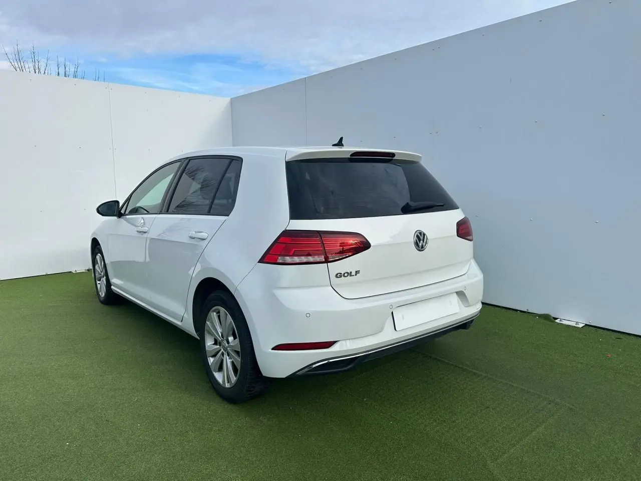 Vue 3/4 arrière droite d'une Volkswagen Golf blanche 5 portes avec feux arrière LED et jantes alliage 16 pouces.