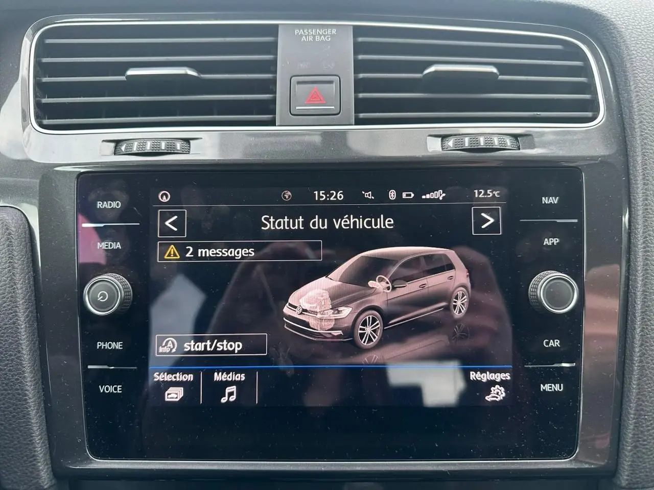 Écran tactile central affichant le statut du véhicule Volkswagen Golf VII, vue intérieure du tableau de bord noir.