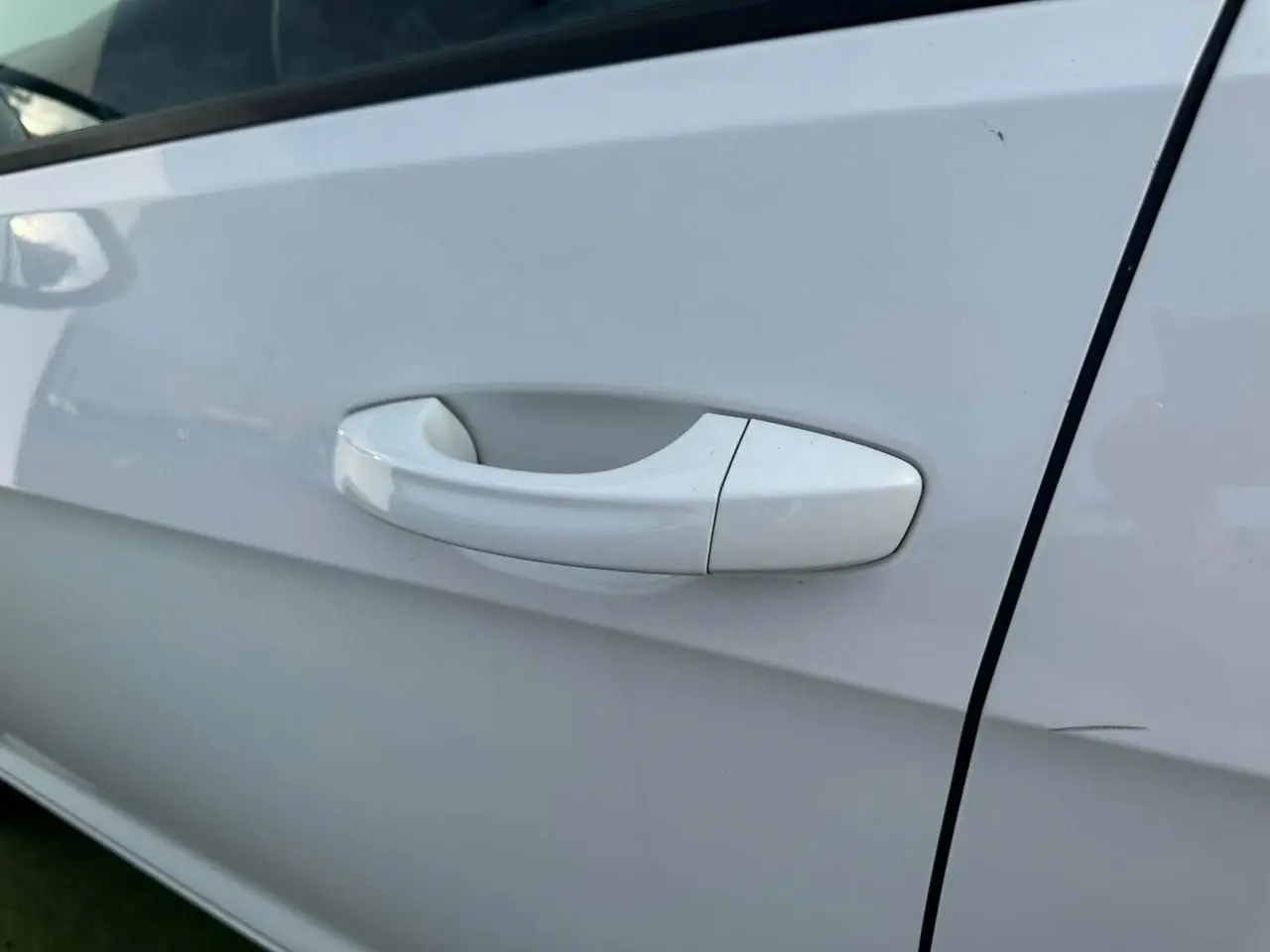 Poignée de porte blanche côté droit d'une Volkswagen Golf VII 2.0 TDI 2018, finition Confortline.