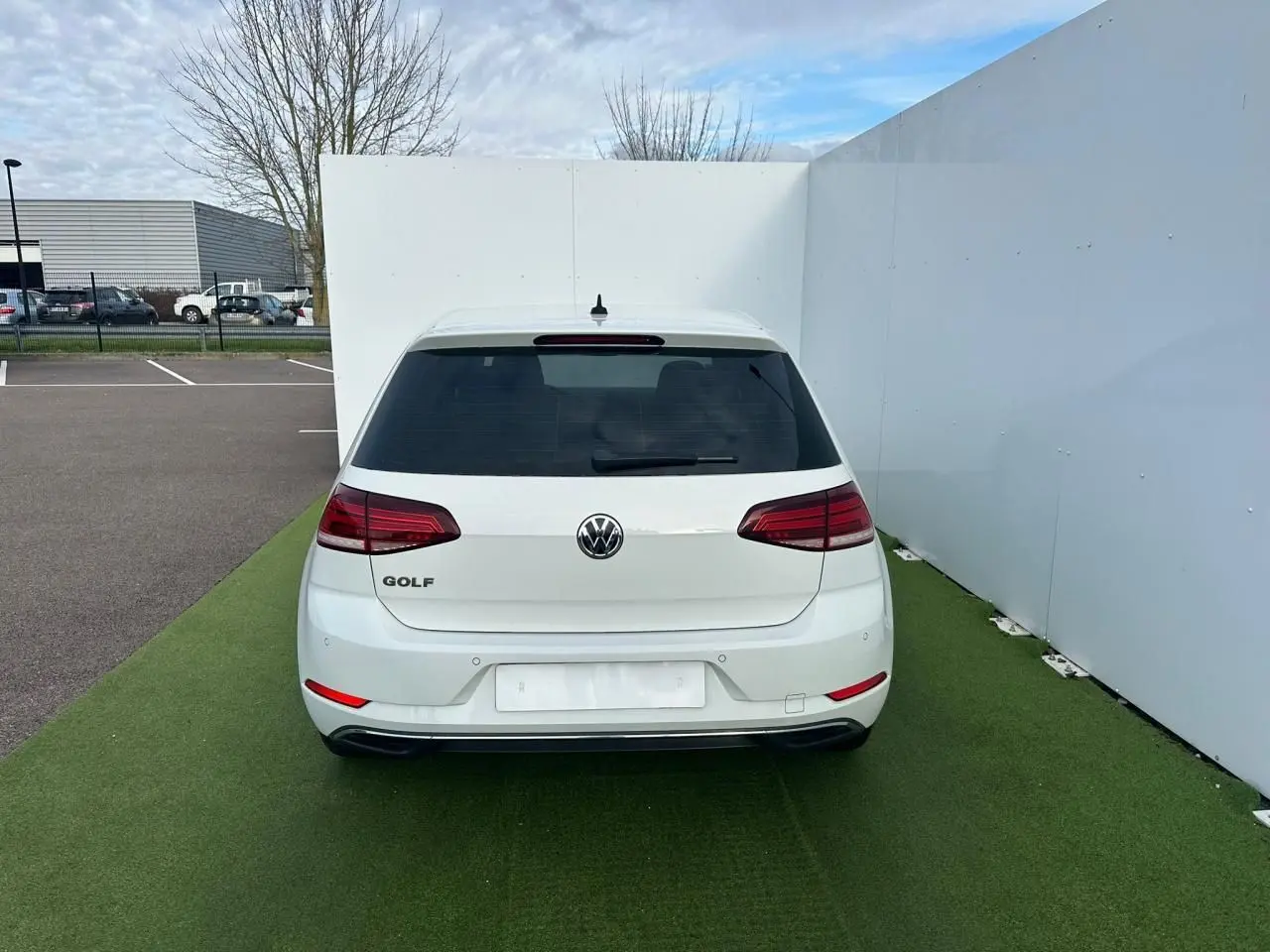 Vue arrière d'une Volkswagen Golf blanche VII 2.0 TDI avec feux arrière LED et pare-chocs couleur carrosserie.