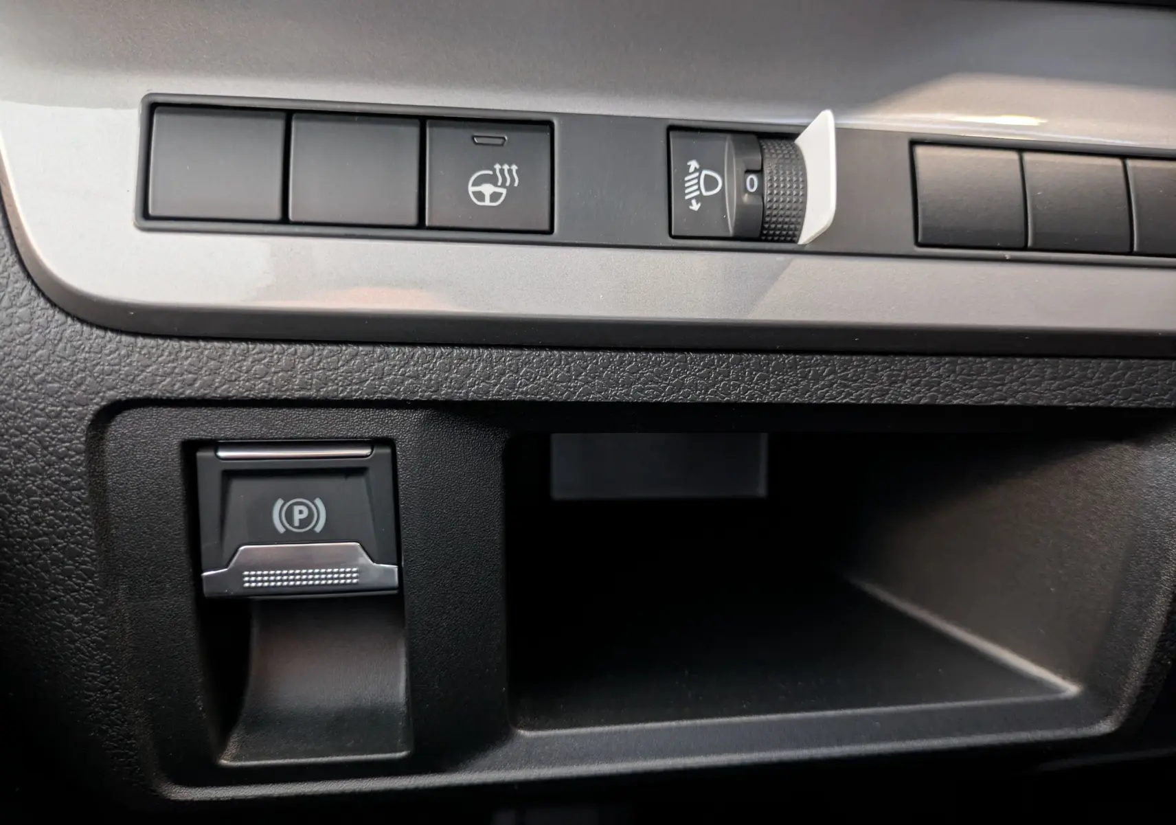 Gros plan sur les commandes noires du tableau de bord du Peugeot Traveller 2026, incluant le frein à main électrique.
