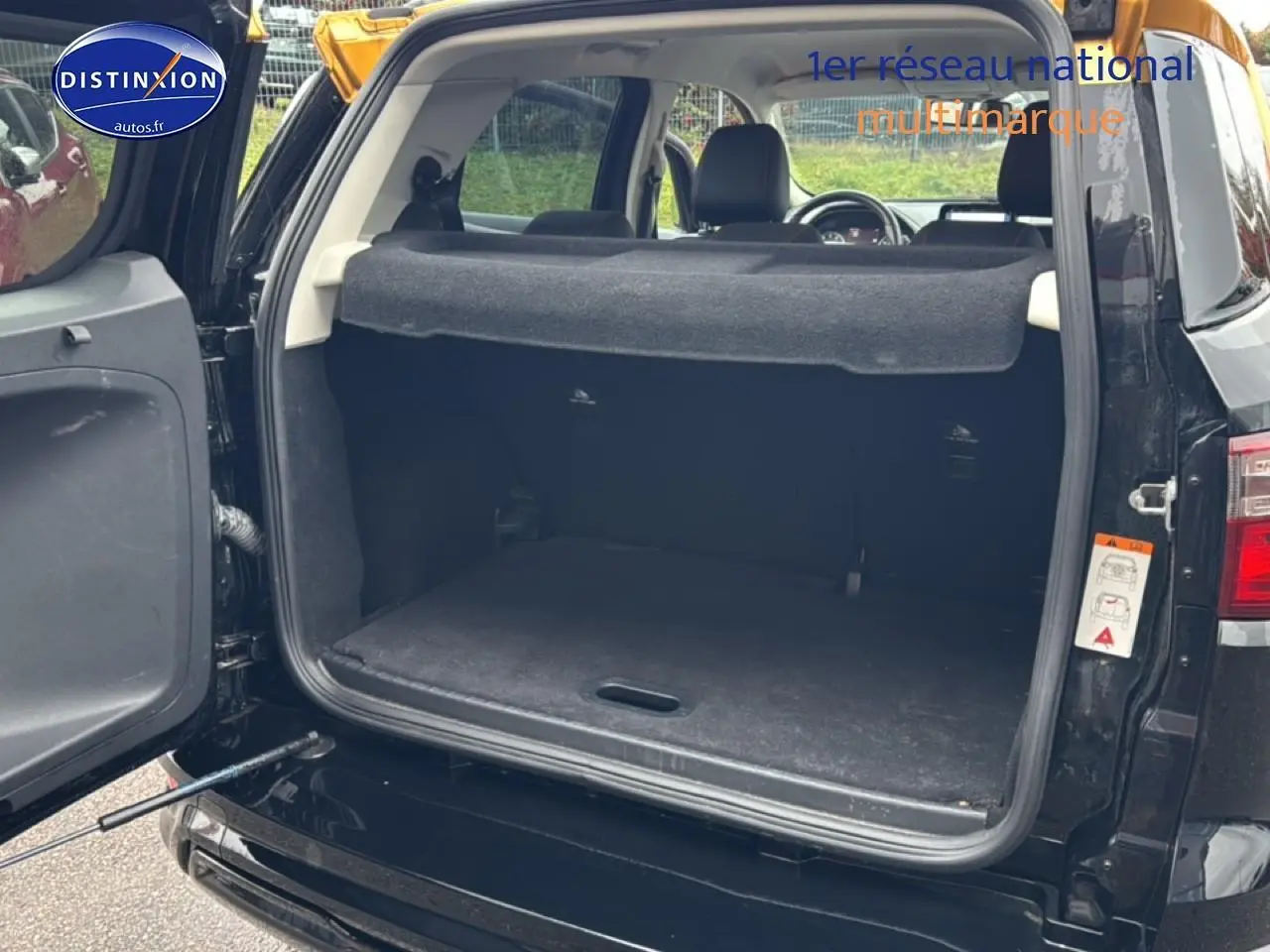 Coffre ouvert vu de l'arrière d'un Ford Ecosport noir, montrant l'espace de chargement et la banquette arrière.