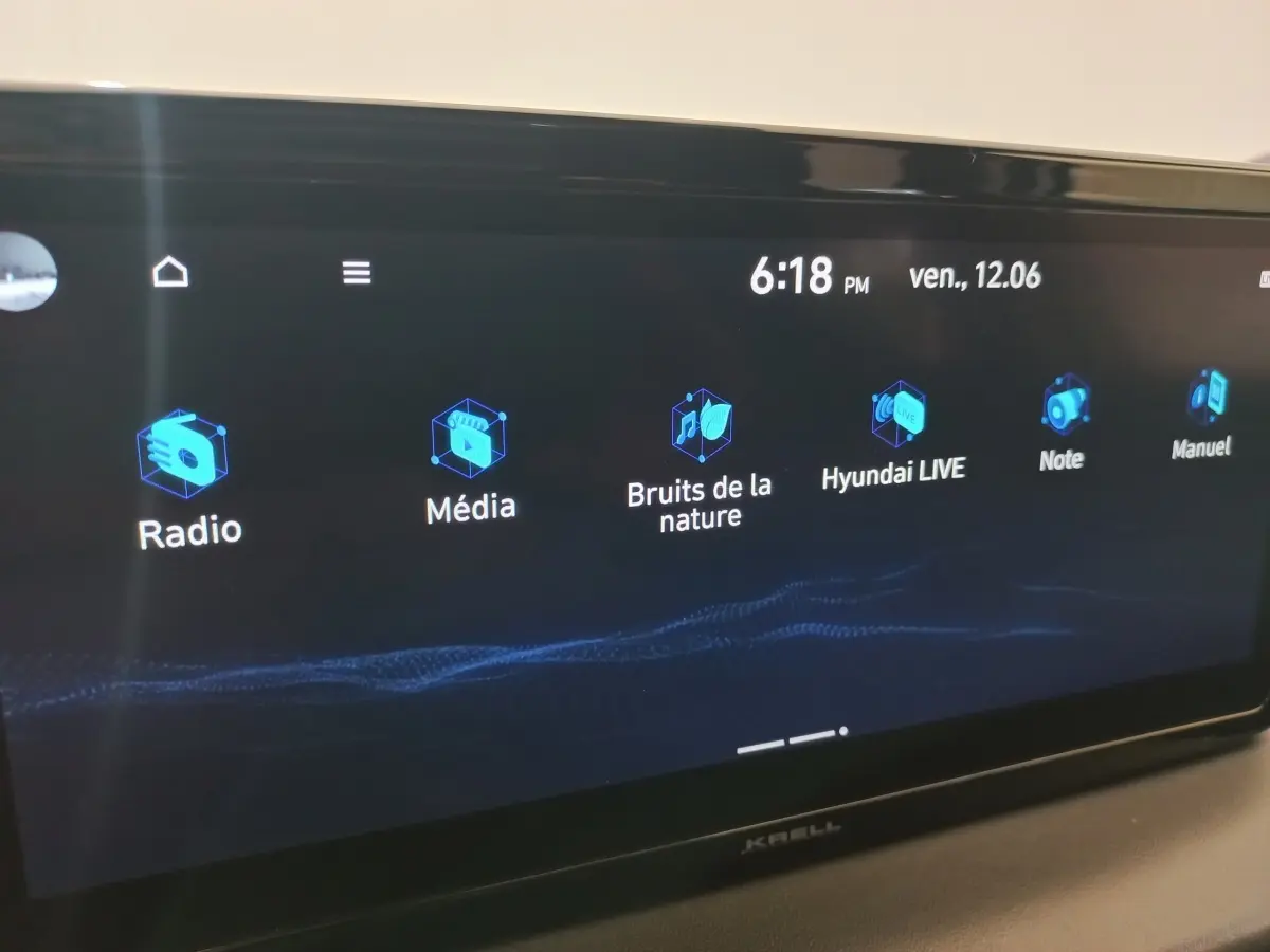 Écran tactile multimédia du tableau de bord du Hyundai Santa Fe hybride gris clair, affichant les options radio et média.