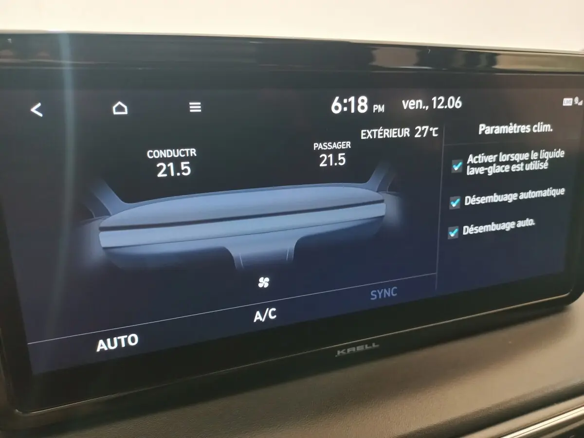 Écran tactile intérieur du Hyundai Santa Fe hybride 2021 affichant la climatisation et paramètres de désembuage.
