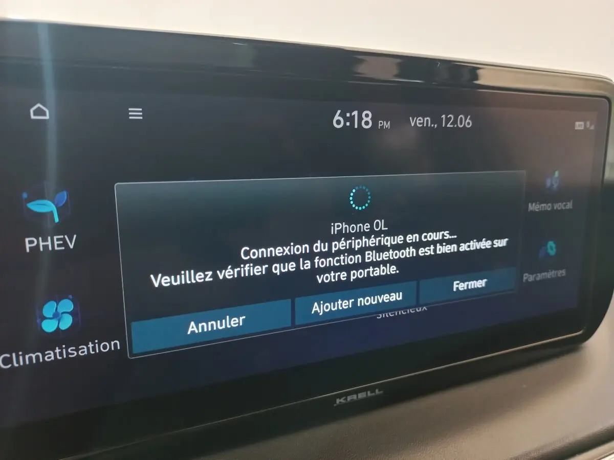 Écran tactile intérieur du Hyundai Santa Fe hybride, affichant la connexion Bluetooth en cours à l’iPhone.