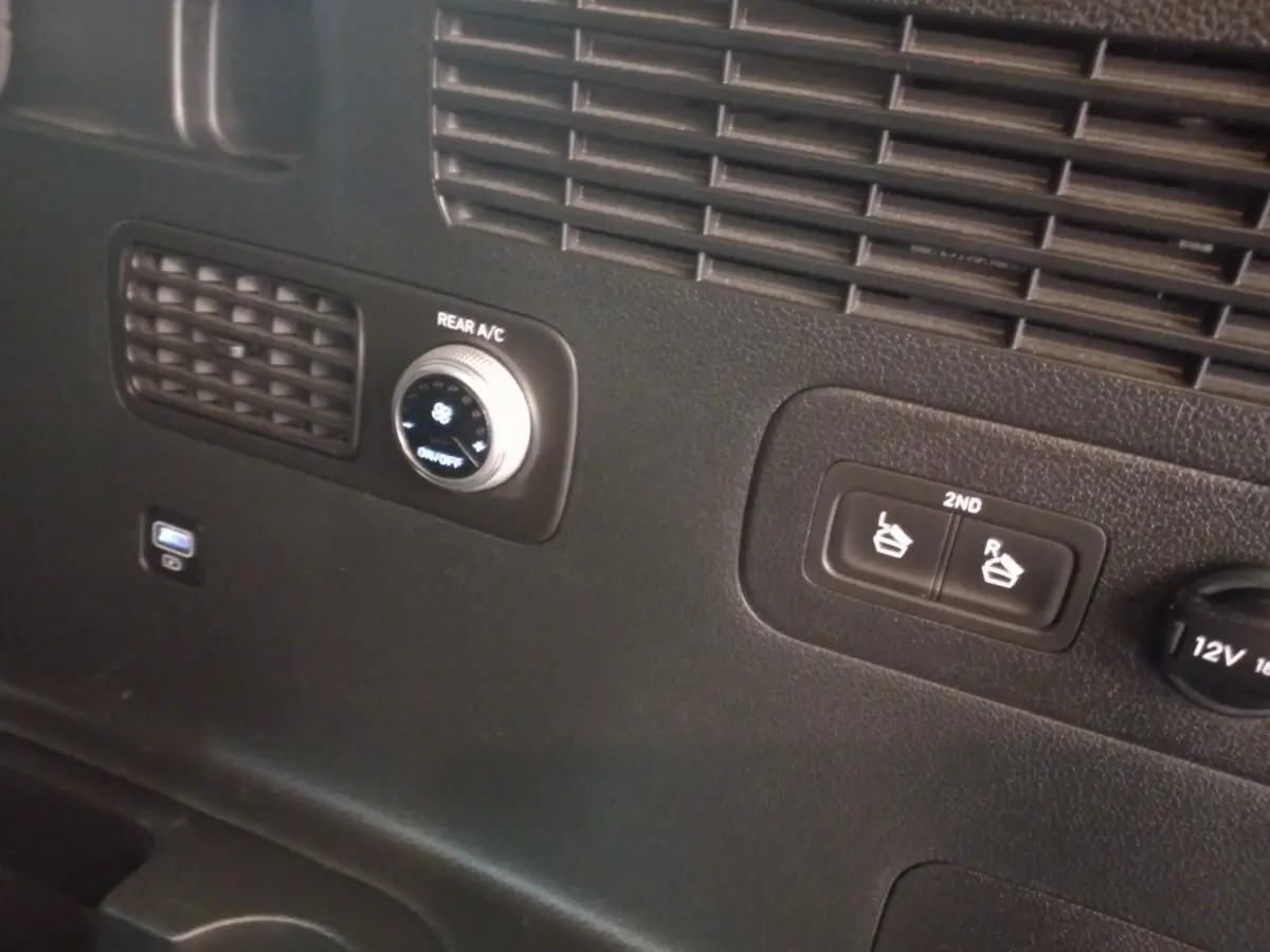 Détail du panneau de commande arrière noir du Hyundai Santa Fe hybride, avec réglage climatisation et boutons sièges 2e rangée.