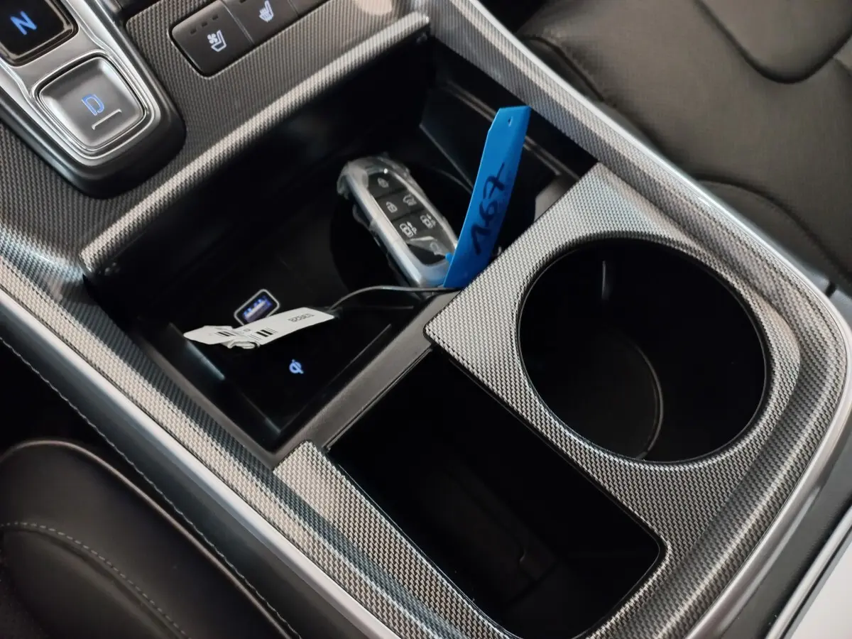Vue rapprochée de la console centrale gris carbone du Hyundai Santa Fe hybride avec clé et ports USB visibles.