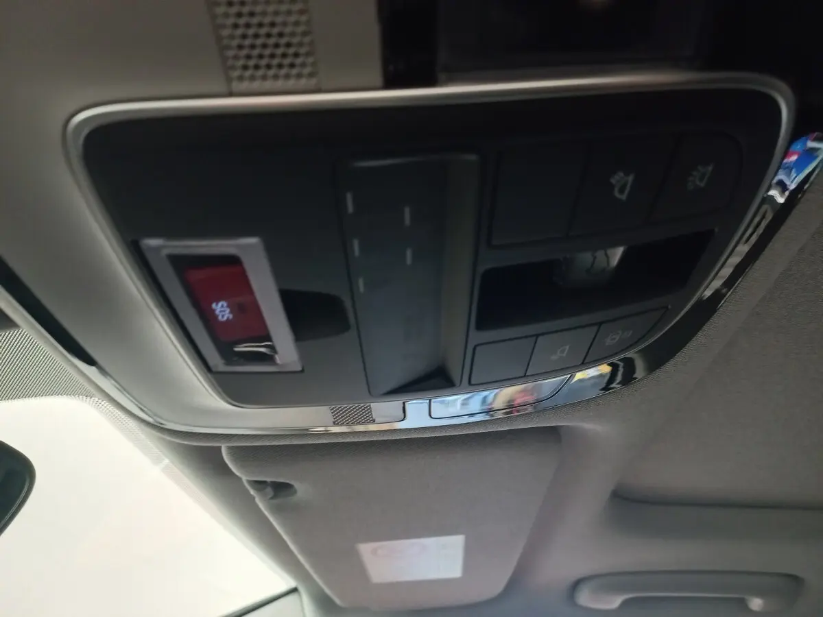 Vue intérieure du panneau de commandes au plafond du Hyundai Santa Fe gris clair, avec bouton SOS rouge visible.