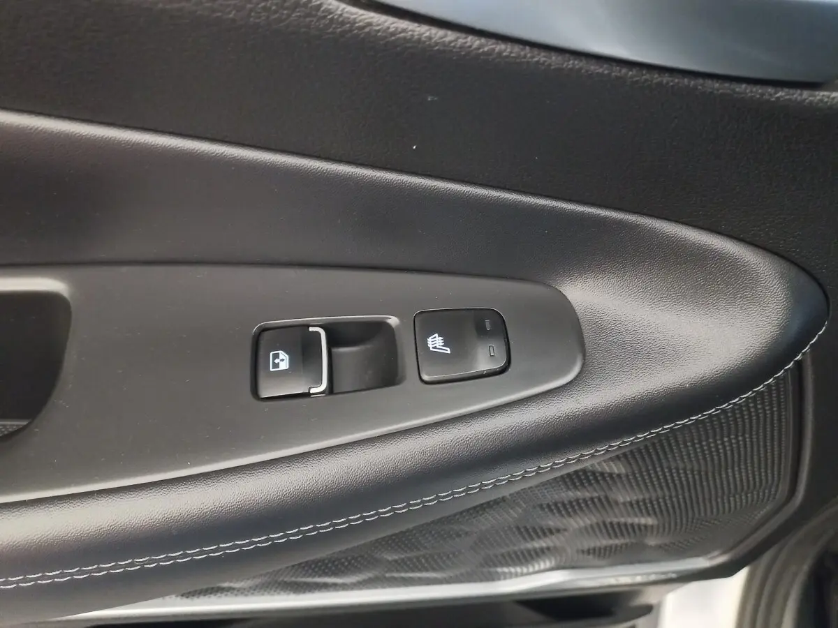 Détail des commandes de la porte côté conducteur du Hyundai Santa Fe gris clair, avec bouton de verrouillage et chauffage de siège.