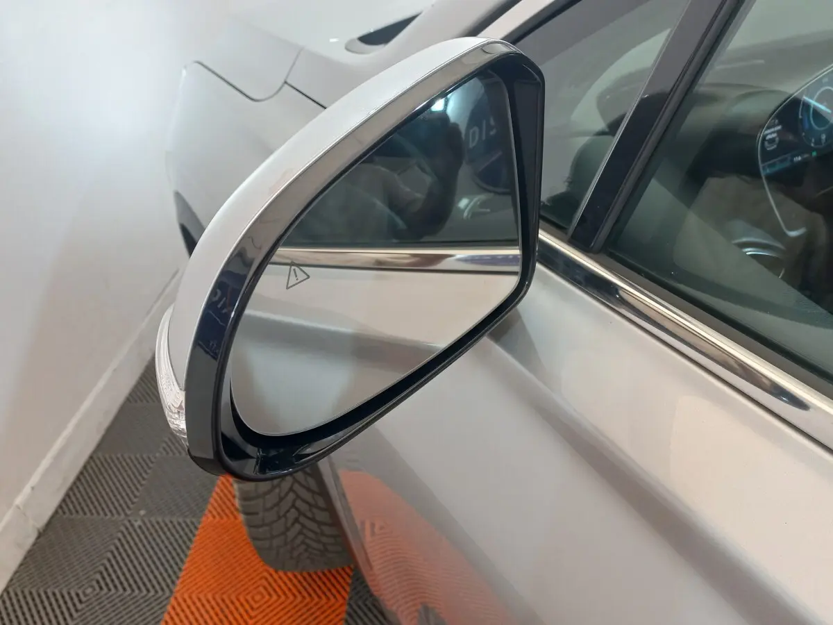 Rétroviseur extérieur droit gris clair du Hyundai Santa Fe hybride rechargeable, vue rapprochée sur la portière et la vitre.