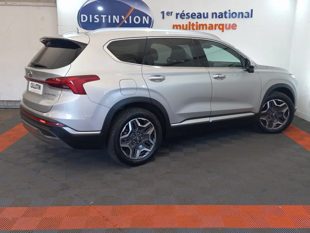Vue latérale droite d’un Hyundai Santa Fe gris clair hybride rechargeable, avec jantes alliage et toit ouvrant électrique.