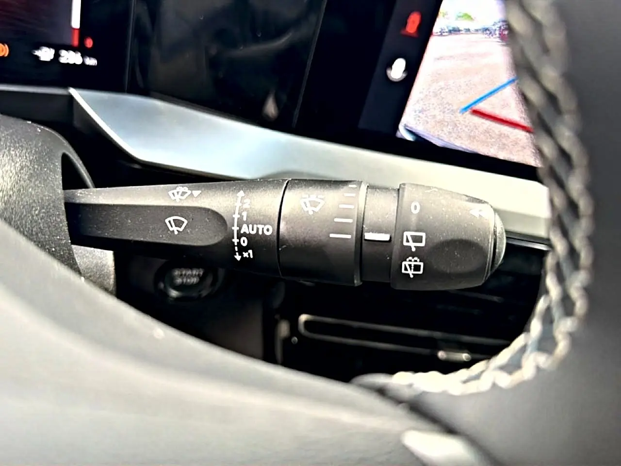 Gros plan sur la commande des essuie-glaces à gauche du volant dans l’habitacle de l’Opel Mokka Electric 2025.