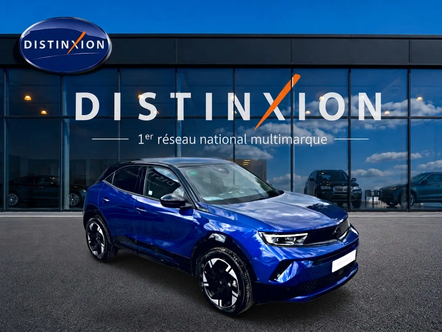 Opel Mokka Electric 156 GS bleu en 3/4 avant droit, avec toit noir et jantes alu distinctives.