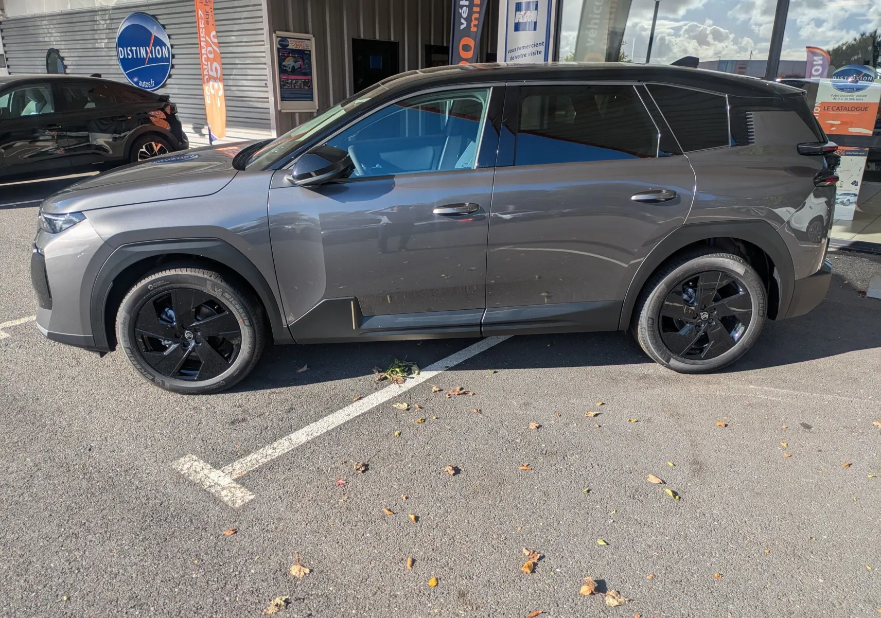Vue de profil côté gauche d'un Citroën C5 Aircross hybride gris platinium avec toit noir et jantes noires.