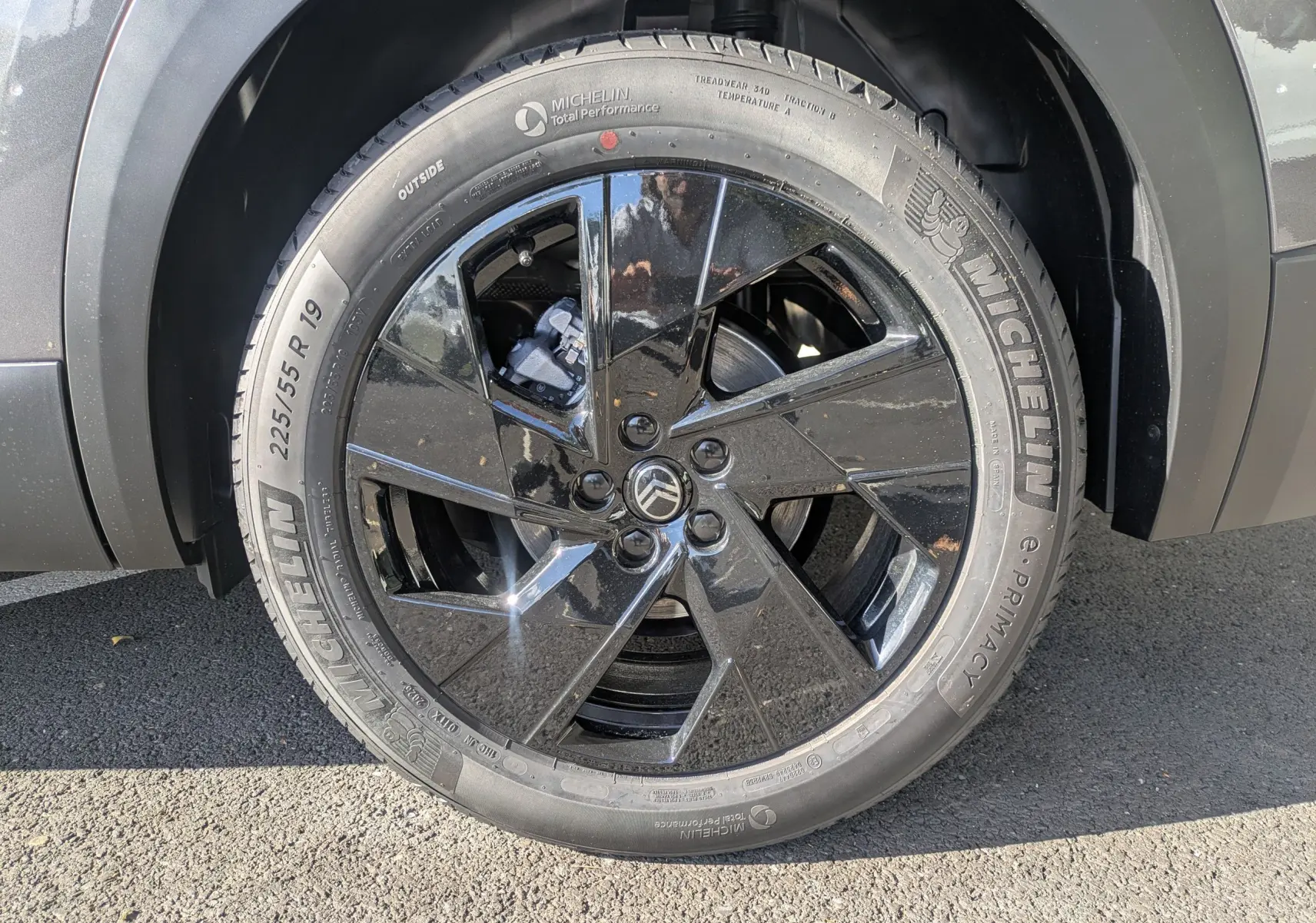 Gros plan sur la roue avant gauche du Citroën C5 Aircross hybride gris platinium avec jante noire brillante.
