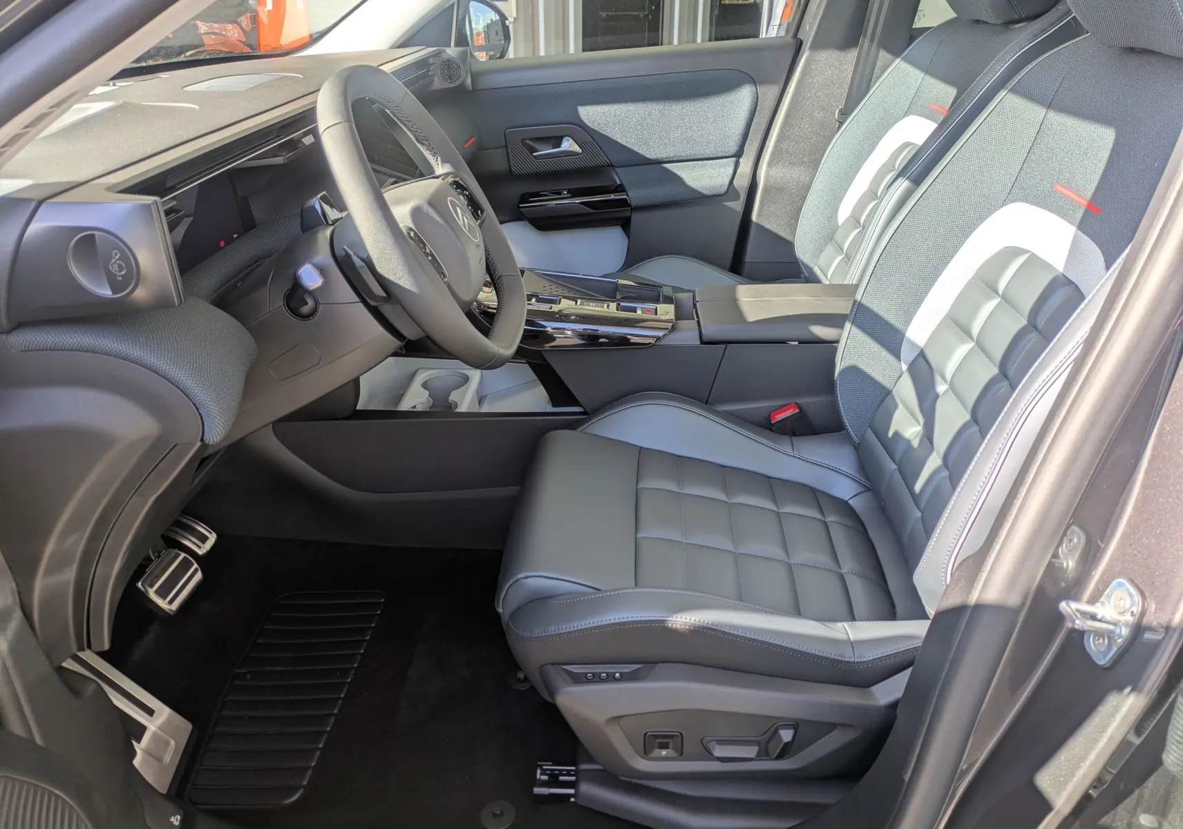 Vue intérieure côté conducteur du Citroën C5 Aircross hybride 2026, sièges cuir gris et tableau de bord moderne.