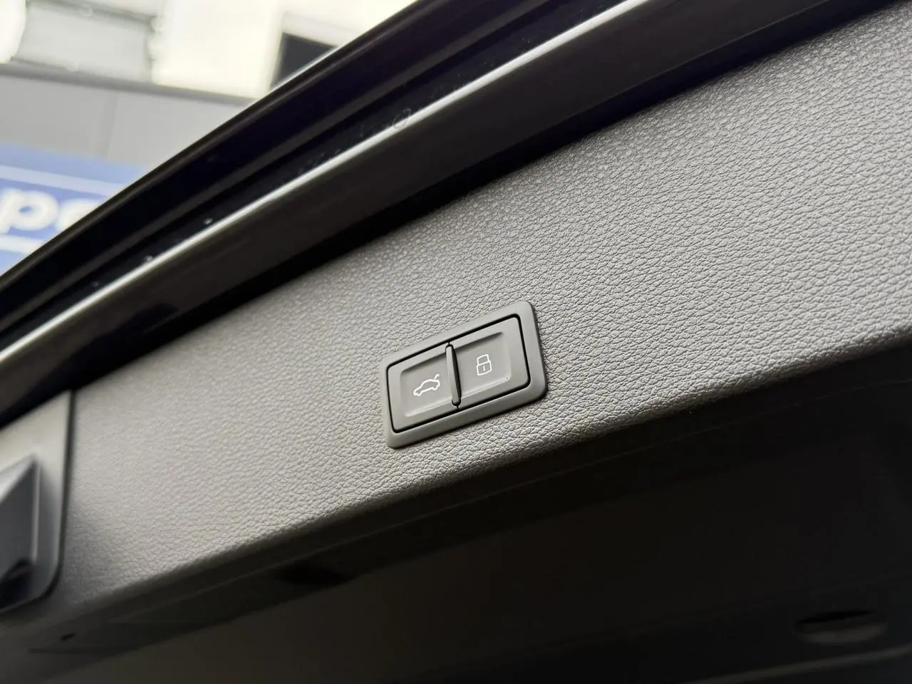 Boutons de commande du hayon électrique et verrouillage sur le panneau intérieur du coffre d'un Audi Q2 noir Mythe 2023.