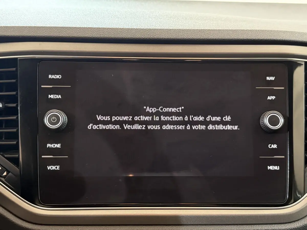 Écran tactile central du tableau de bord du Volkswagen T-Roc noir, affichant un message d'activation App-Connect.
