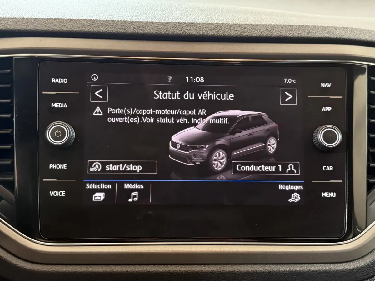 Écran tactile du tableau de bord affichant le statut d’un Volkswagen T-Roc noir en vue 3/4 avant droite.