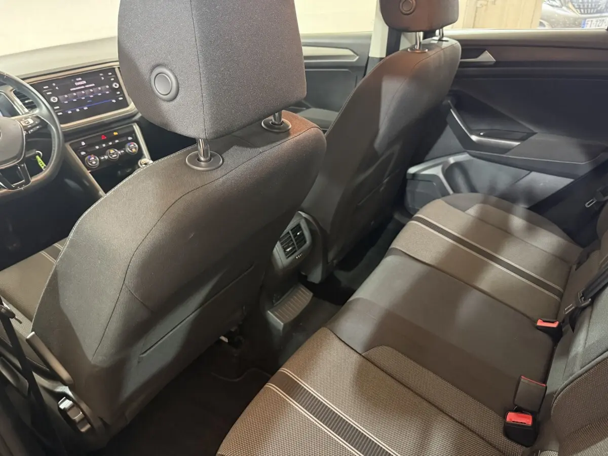 Vue intérieure arrière du Volkswagen T-Roc noir 2020, montrant les sièges arrière et la console centrale avec aérateurs.