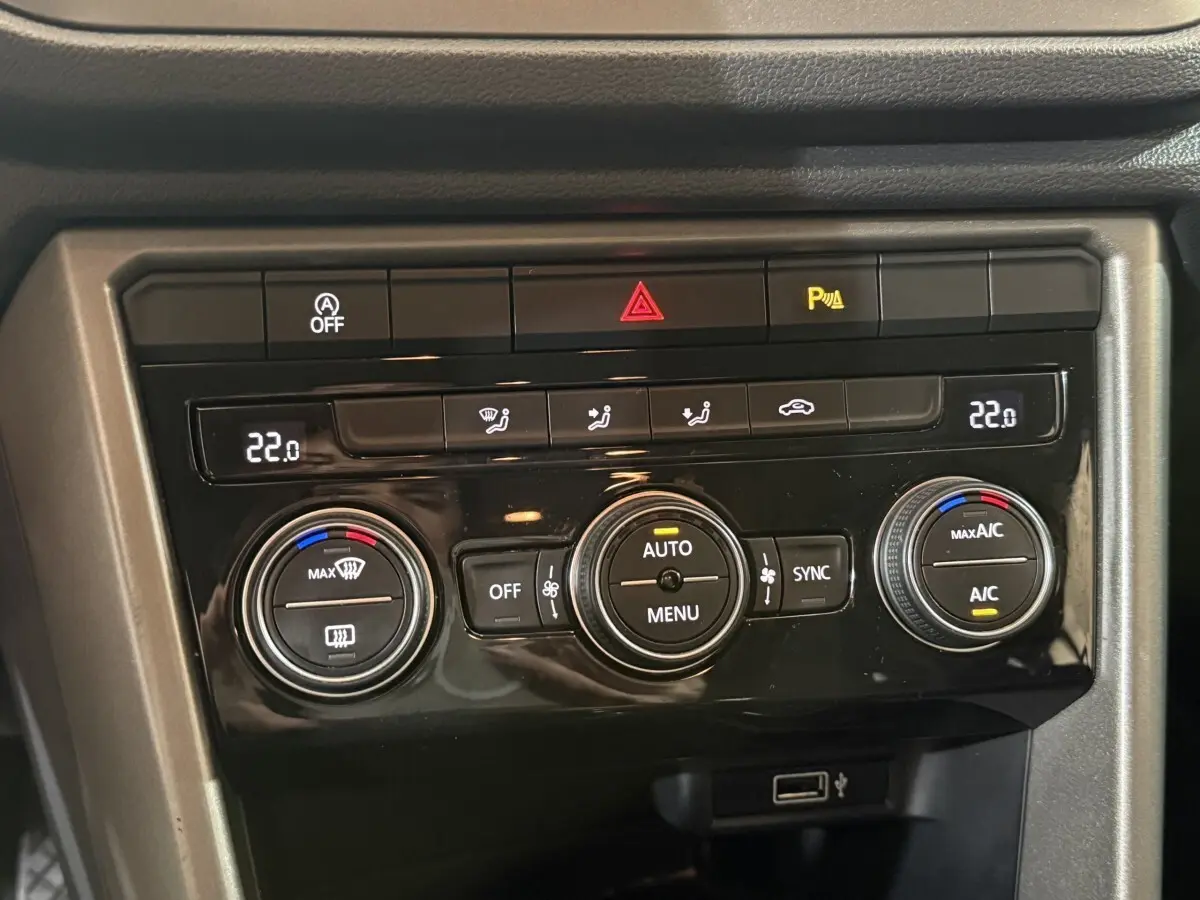 Panneau de commande de climatisation noir du Volkswagen T-Roc 2020, avec affichage digital et boutons circulaires.