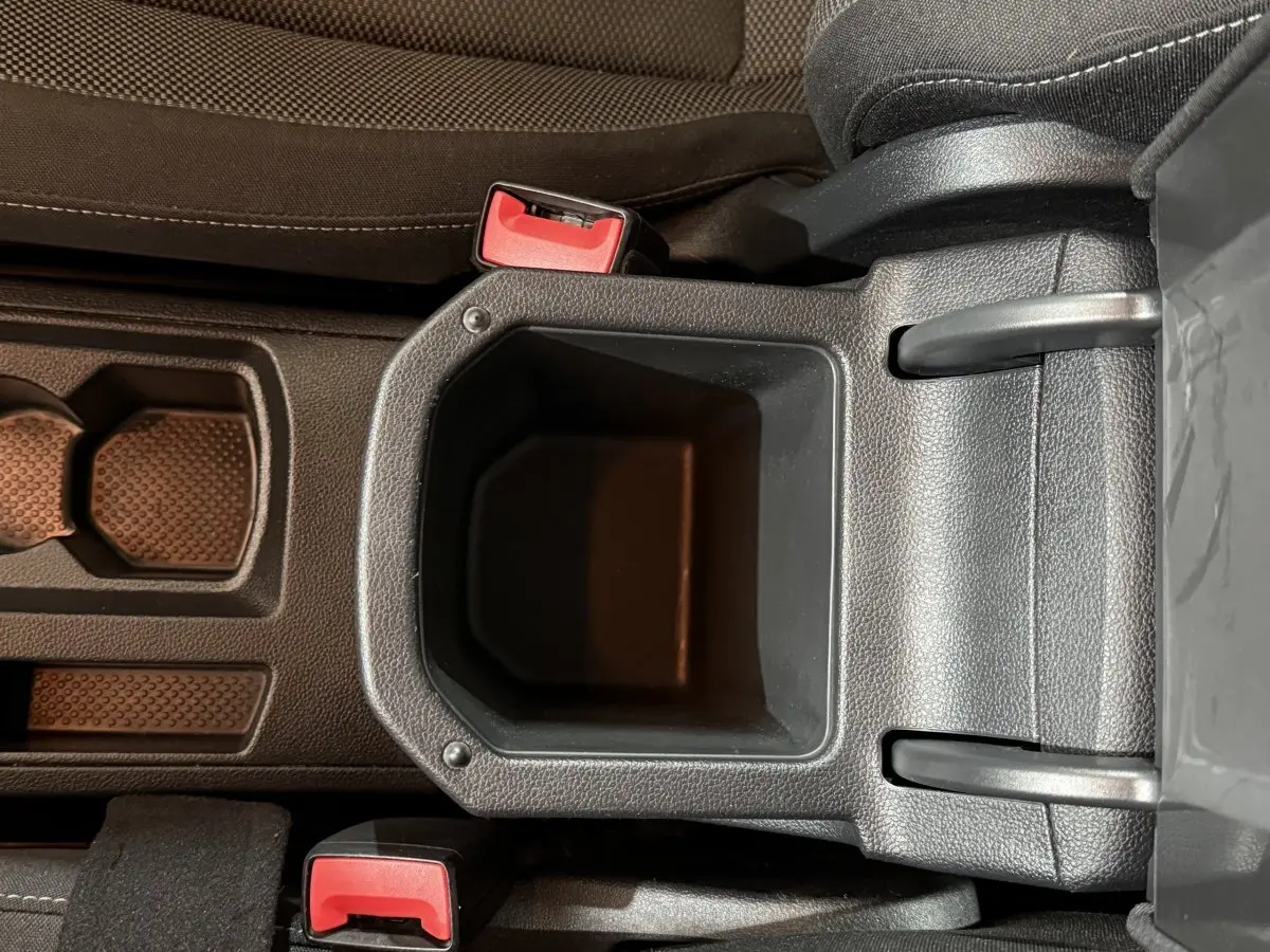 Vue plongeante sur le rangement central noir et les ceintures rouges du Volkswagen T-Roc 1.0 TSI 115 Lounge Business 2020.