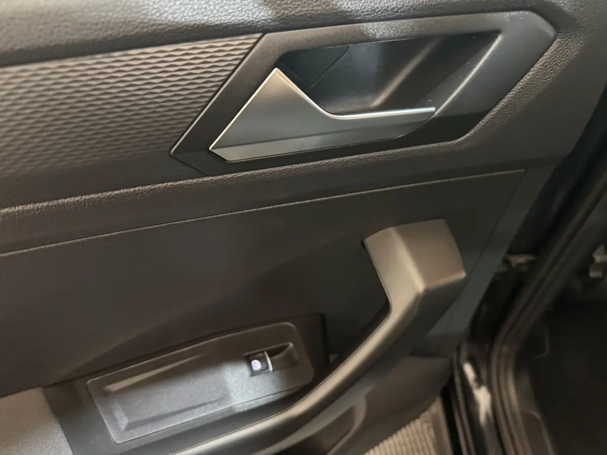 Détail de la porte avant gauche noire du Volkswagen T-Roc 2020 avec poignée argentée et commande de verrouillage.