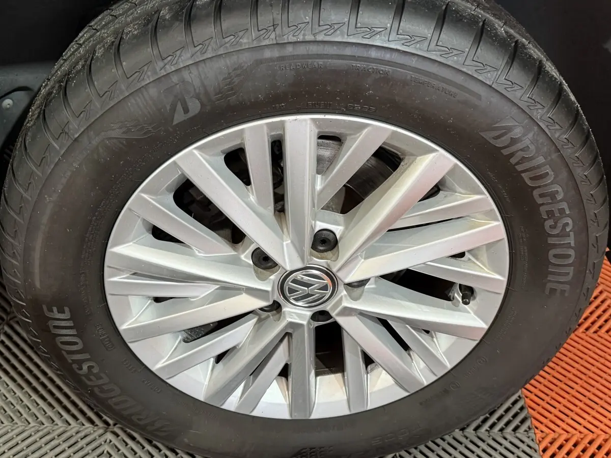 Gros plan sur la roue avant droite d’un Volkswagen T-Roc noir avec jante argentée et pneu Bridgestone.