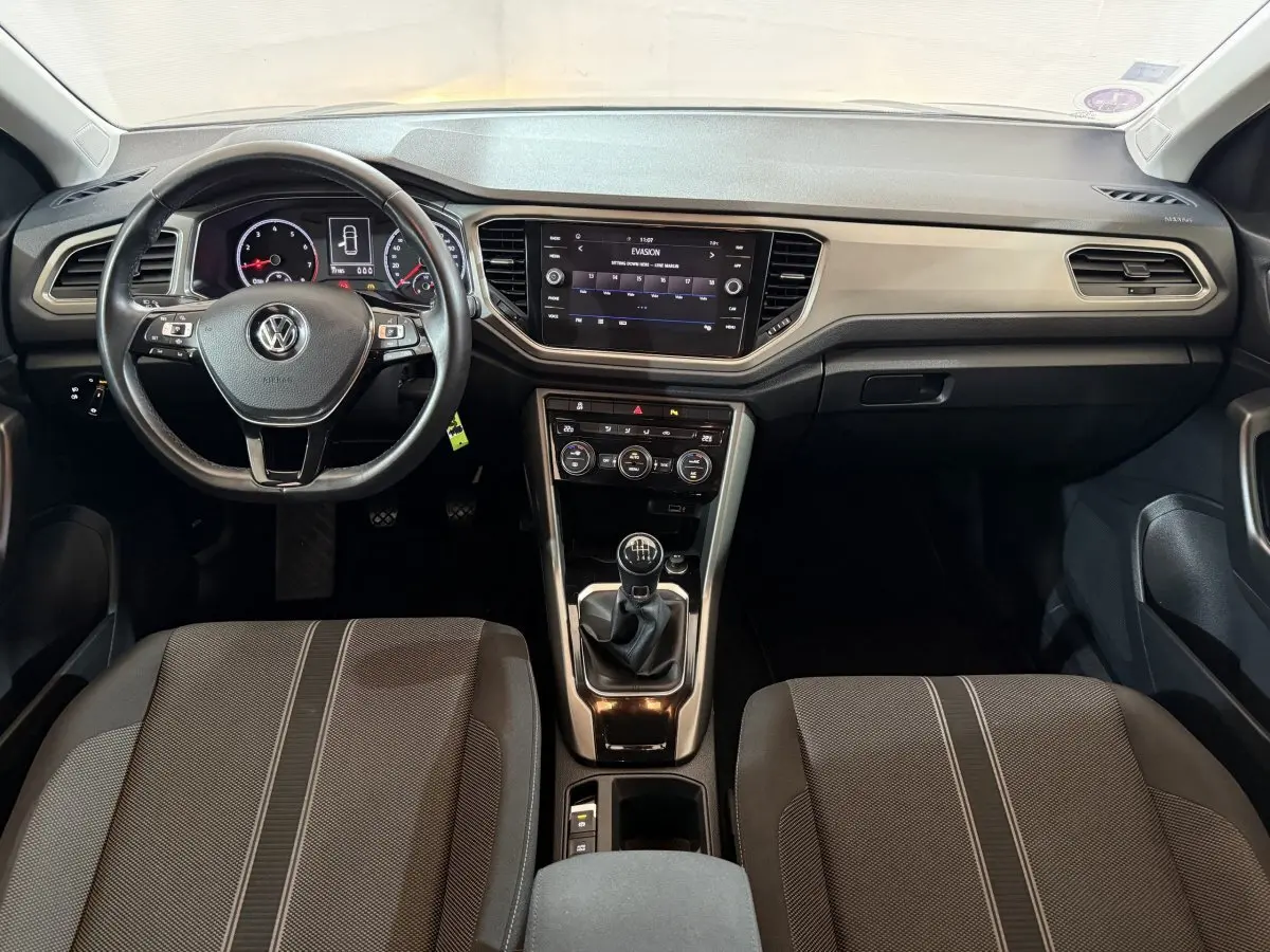 Intérieur Volkswagen T-Roc 2020, vue avant centrée sur tableau de bord avec volant cuir et écran tactile 8 pouces.