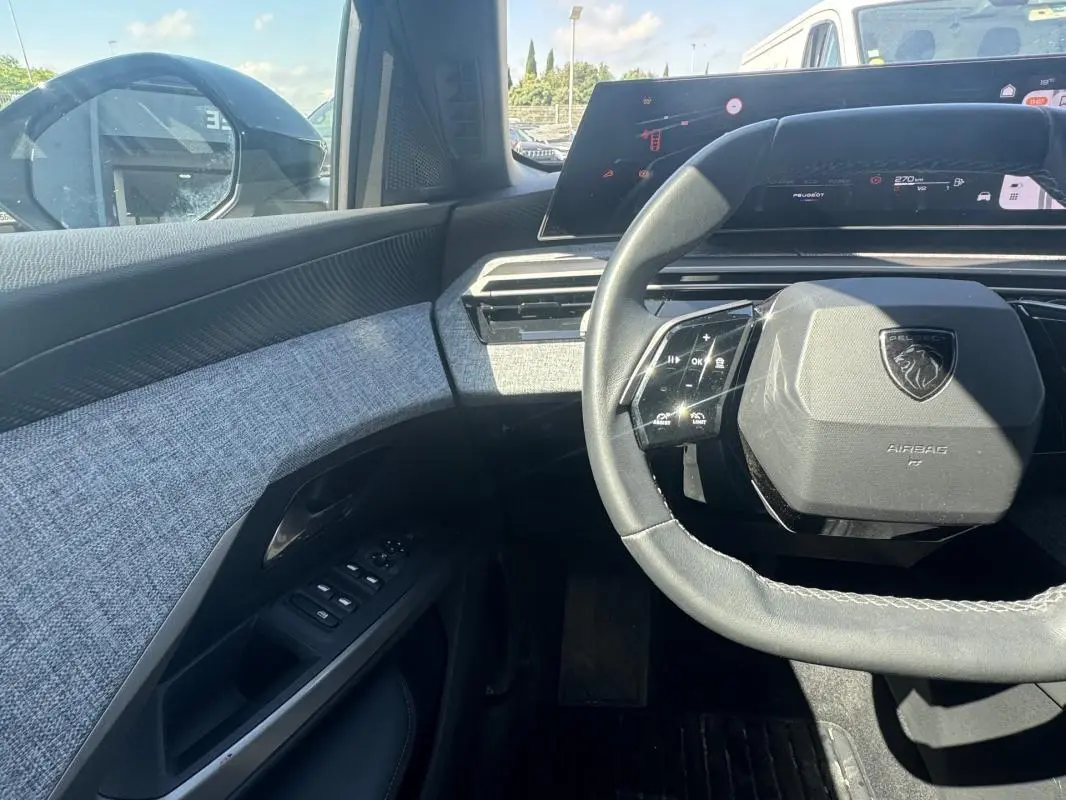 Vue intérieure côté conducteur du Peugeot 3008 Hybrid 136 Allure 2025, volant compact et tableau de bord numérique.