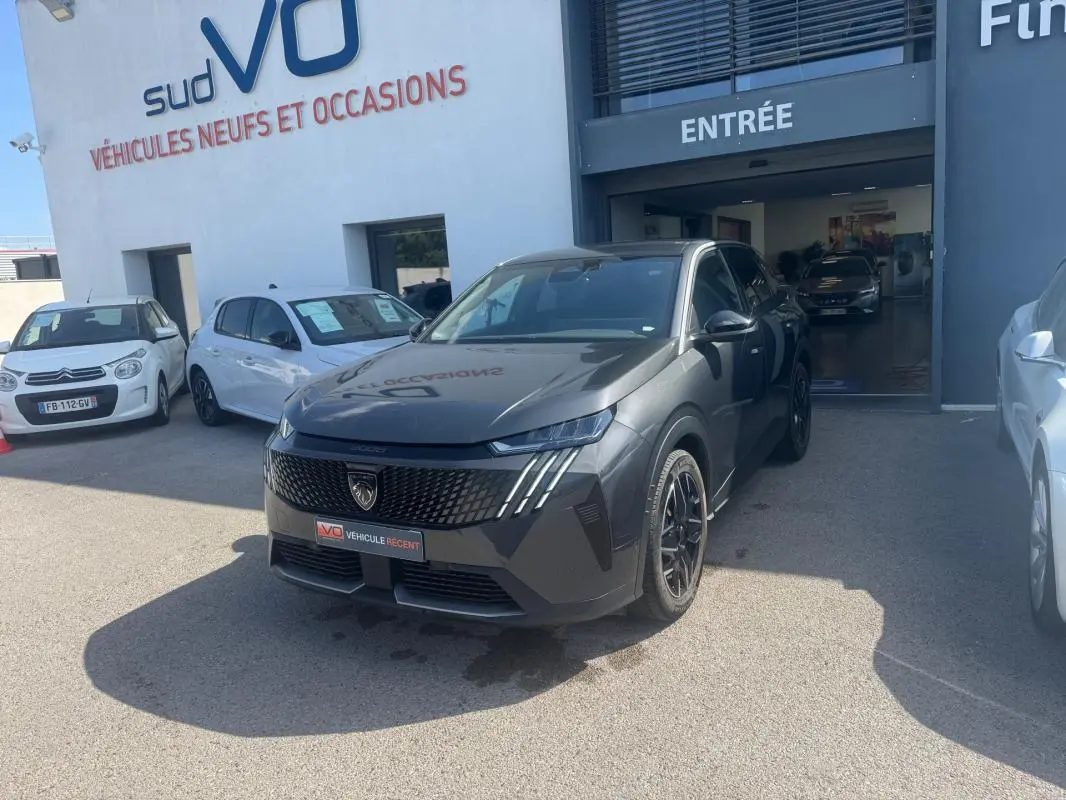Peugeot 3008 Hybrid gris foncé en 3/4 avant droit, avec calandre noire et jantes alliage 19 pouces visibles.