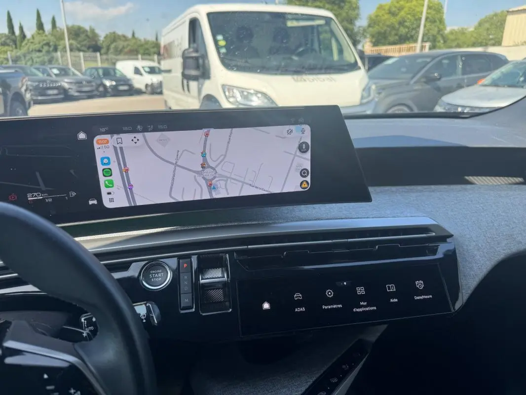 Vue intérieure du tableau de bord du Peugeot 3008 Hybrid 136 e-DCS6 Allure 2025, avec écran tactile et navigation affichée.