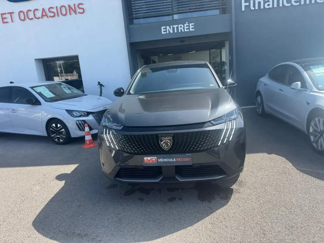 Peugeot 3008 Hybrid gris foncé vue de face, mettant en valeur la calandre et les feux LED distinctifs en griffes.