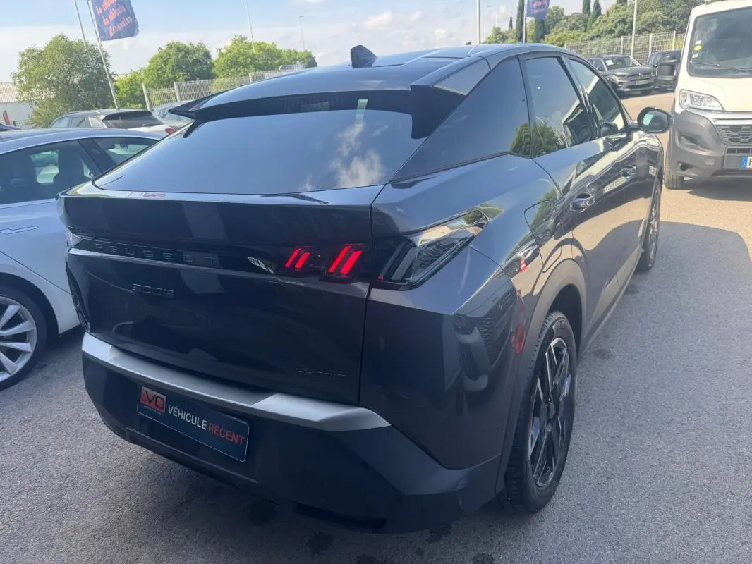 Vue 3/4 arrière droite d'un Peugeot 3008 Hybrid gris foncé avec feux arrière LED distinctifs et jantes alliage 19 pouces.