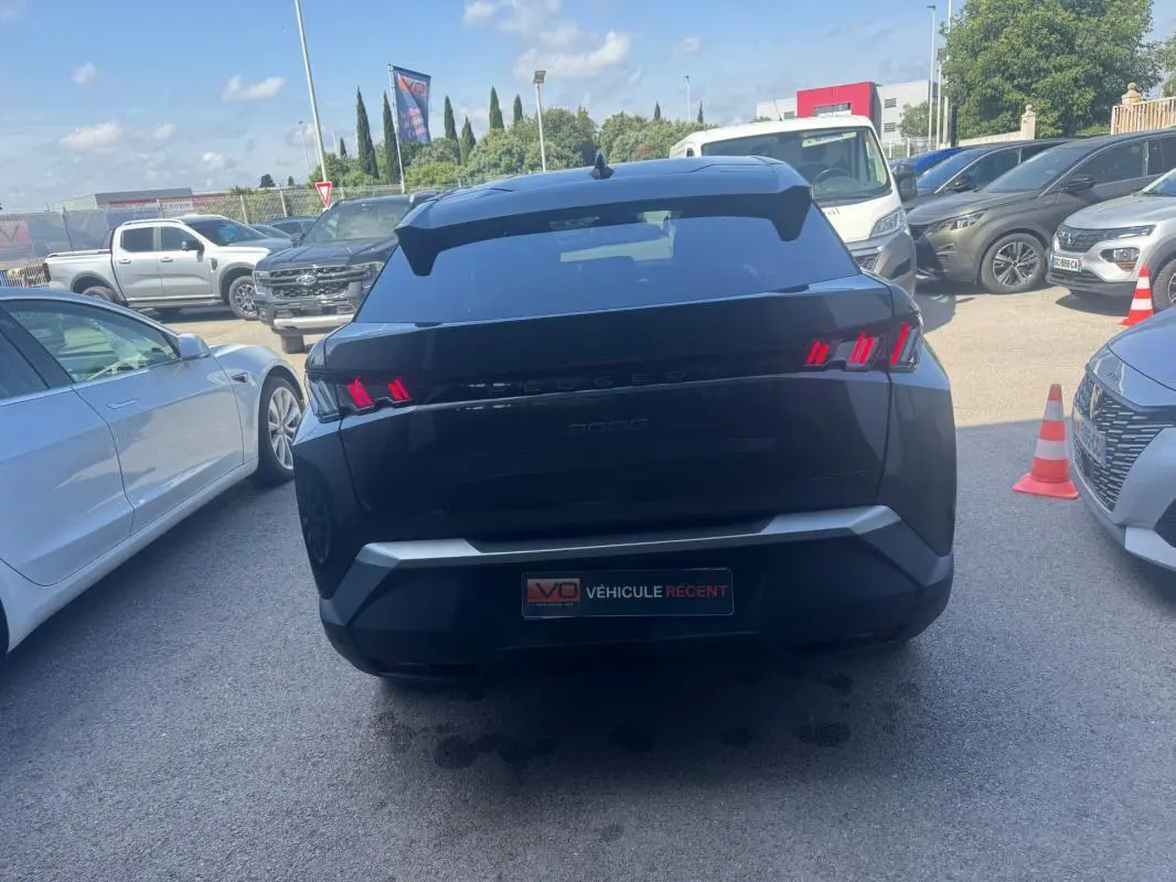 Vue arrière d’un Peugeot 3008 Hybrid gris foncé avec feux arrière LED caractéristiques et jantes alliage 19 pouces.