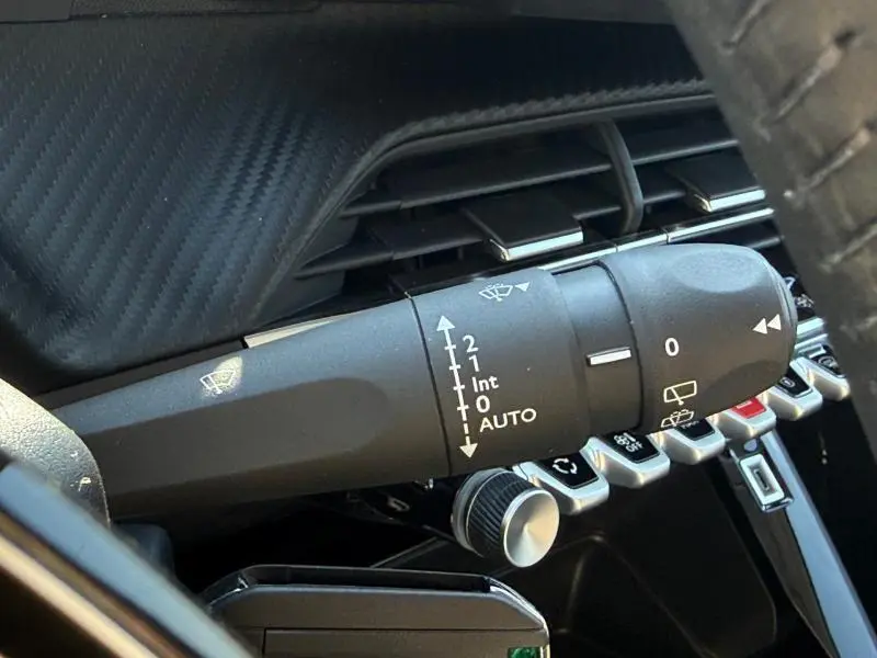 Gros plan sur la commande d’essuie-glace côté droit du tableau de bord d’une Peugeot 208 gris Selenium 2026.