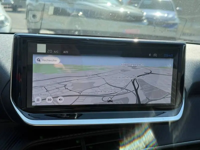 Écran tactile central affichant la navigation dans l’habitacle d’une Peugeot 208 gris Selenium, vue de face.