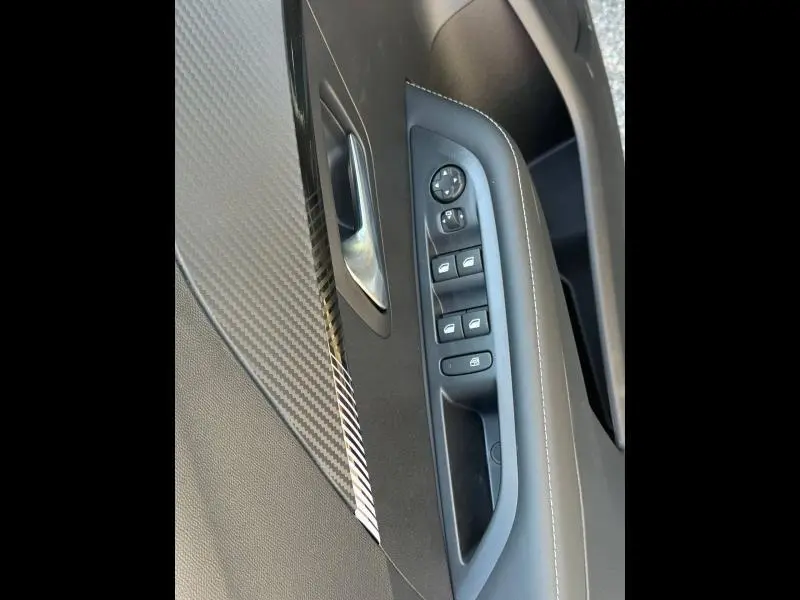 Gros plan sur la commande des vitres et rétroviseurs côté gauche intérieur de la Peugeot 208 gris Selenium.