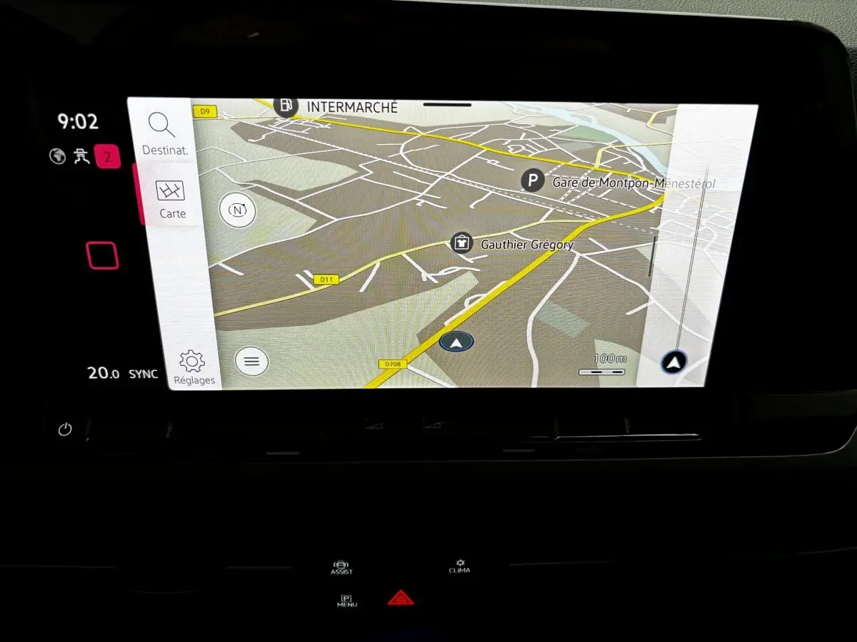 Écran tactile central de navigation du Volkswagen Golf noir 2024, affichant une carte détaillée avec options et réglages visibles.