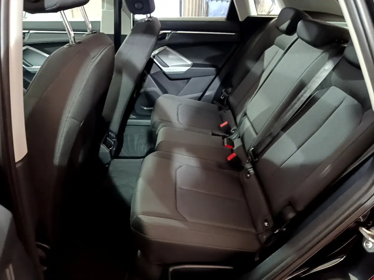 Vue latérale intérieure des sièges arrière noirs de l'Audi Q3 35 TDI 150 S tronic Business Line de 2020.