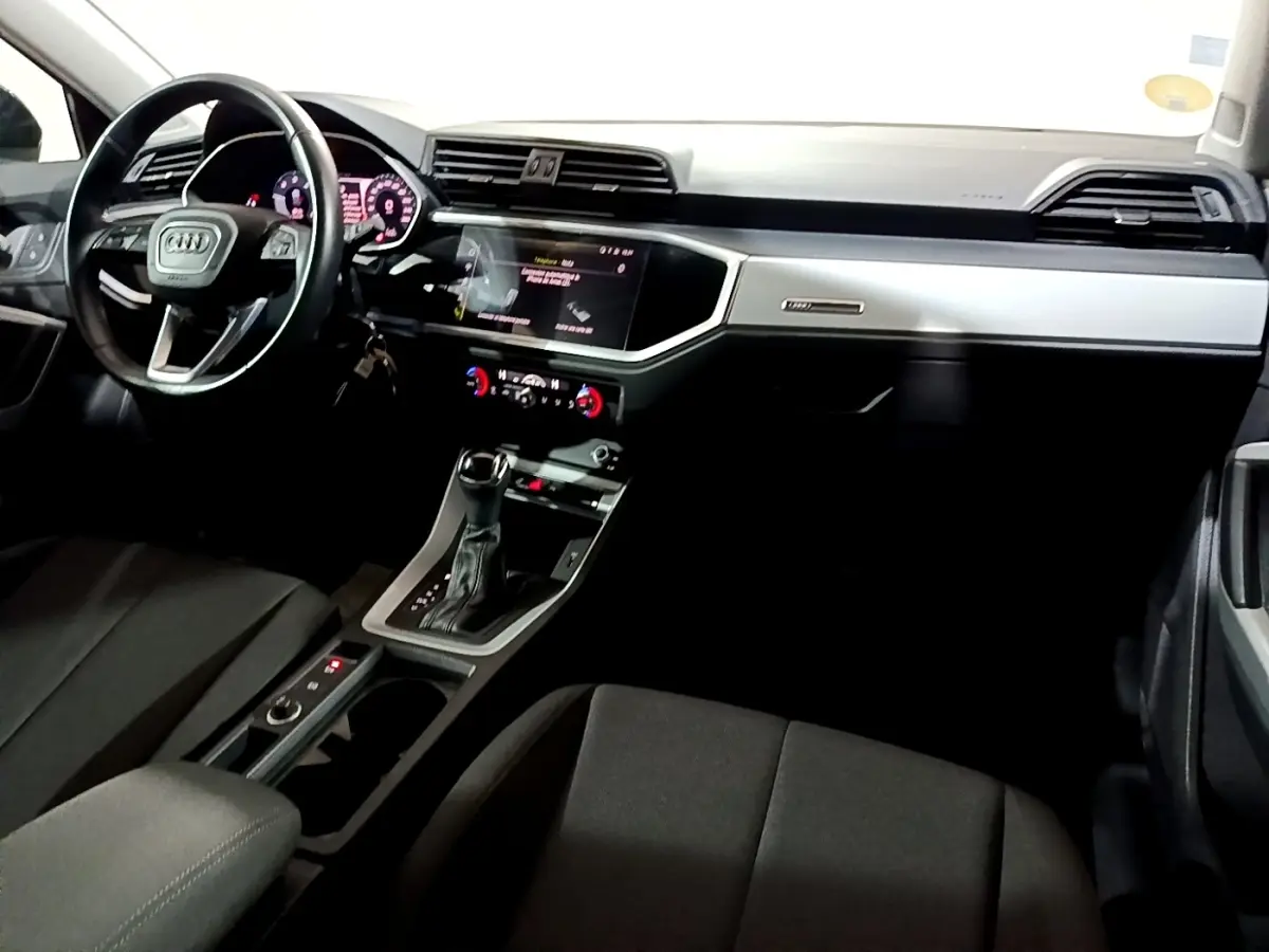 Intérieur noir de l'Audi Q3 35 TDI 2020 vu côté conducteur, avec tableau de bord digital et console centrale moderne.