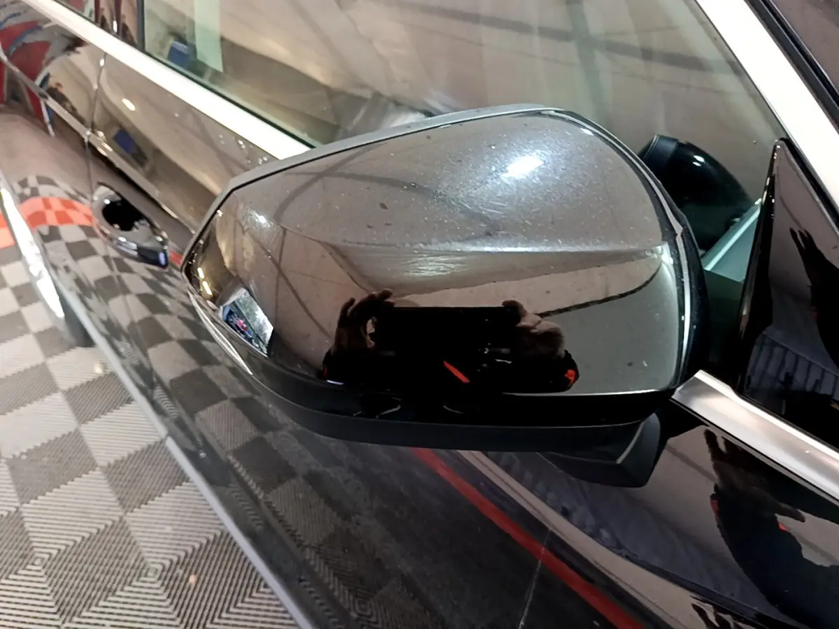 Rétroviseur extérieur côté gauche noir brillant d'un Audi Q3 35 TDI 2020 avec carrosserie noire vue en gros plan.