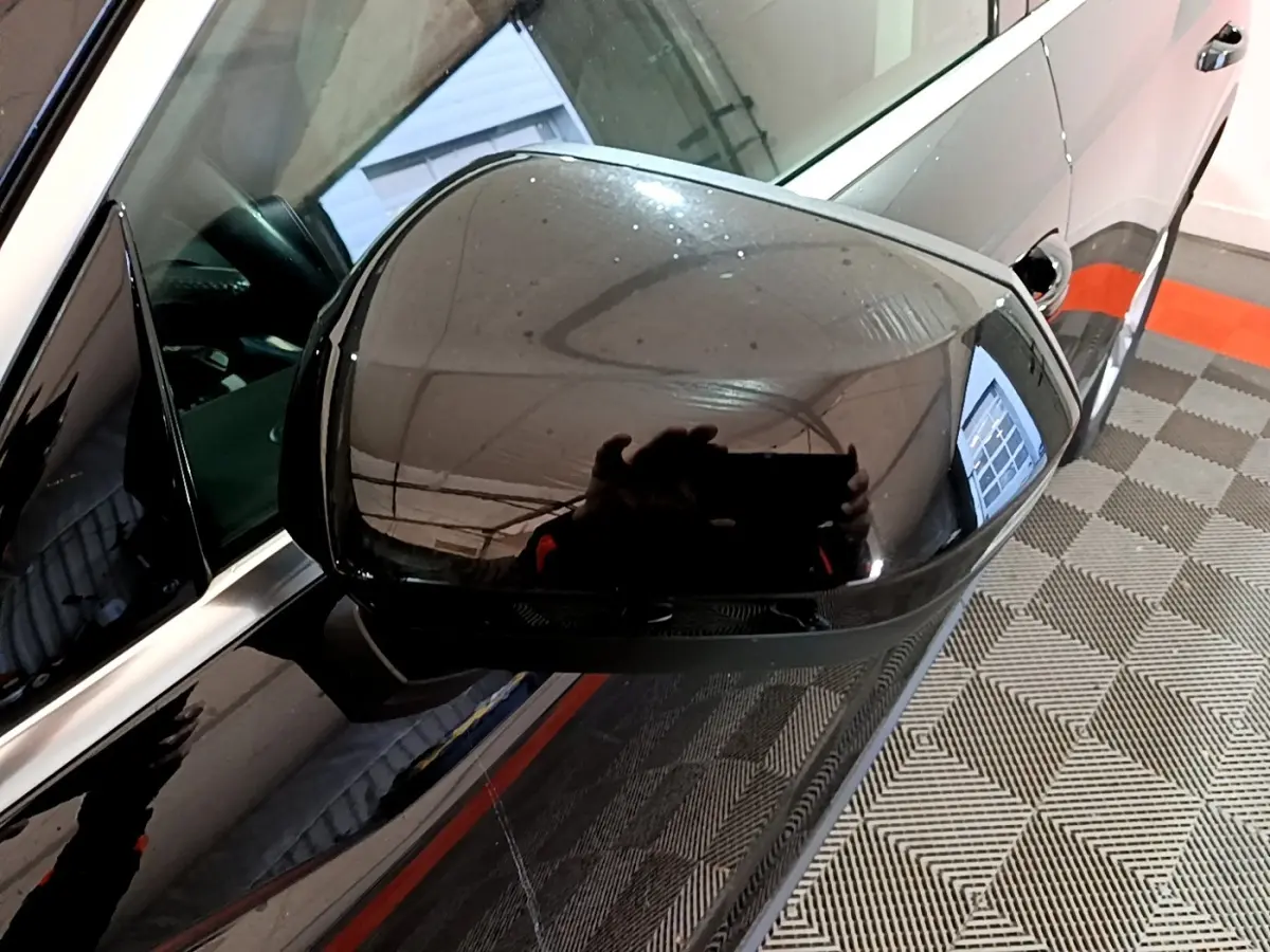 Rétroviseur côté gauche noir brillant d'un Audi Q3 35 TDI 150 S tronic Business Line, vue rapprochée en intérieur.