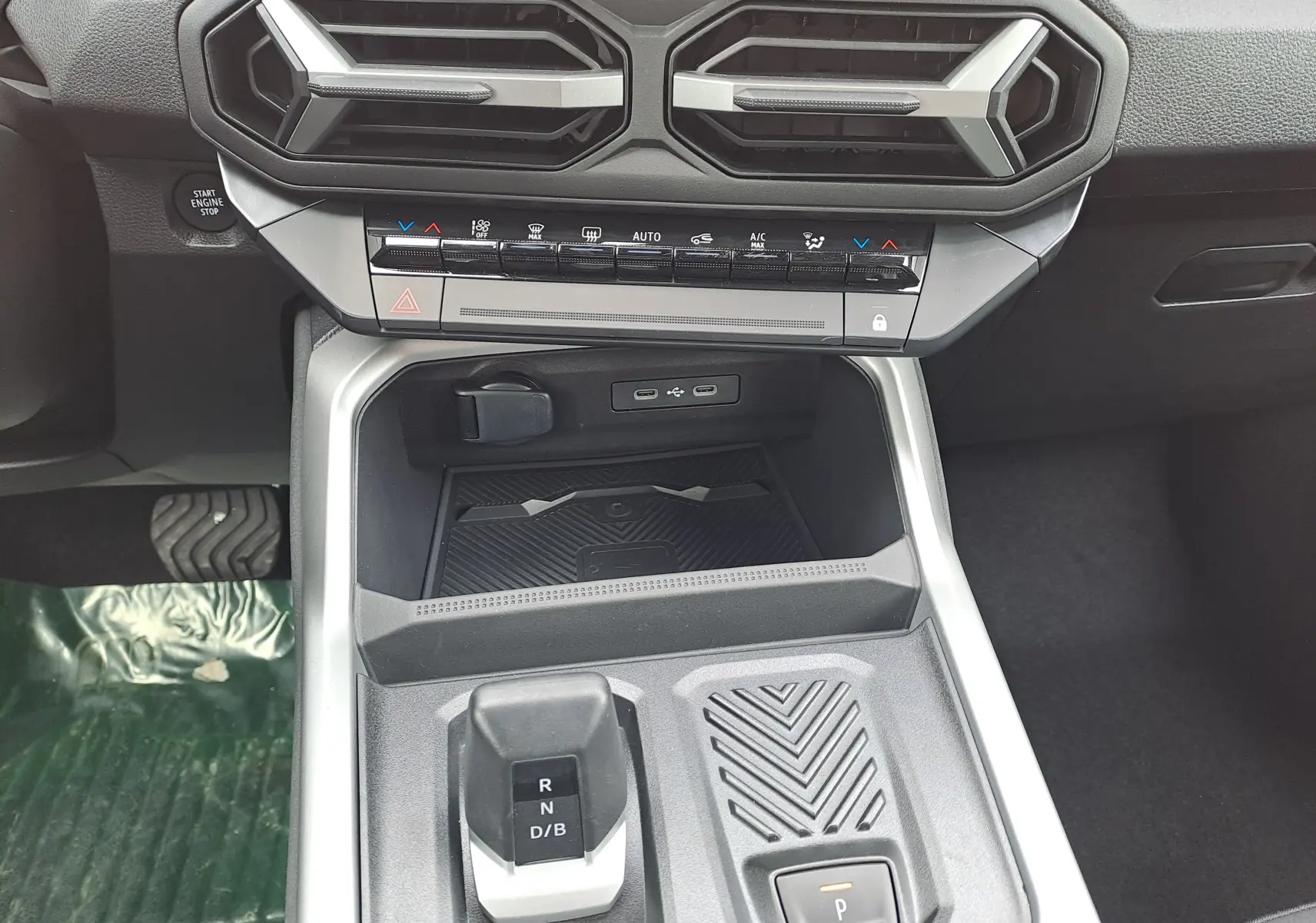 Vue rapprochée de la console centrale intérieure grise du Dacia Bigster Hybrid 155 avec levier de vitesses automatique et commandes climatisation.