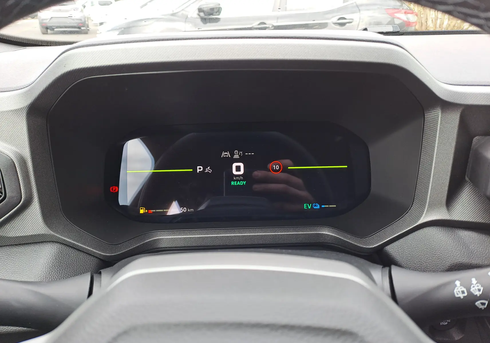 Vue rapprochée du tableau de bord numérique du Dacia Bigster Hybrid 155, affichant la vitesse à zéro et l'autonomie restante.