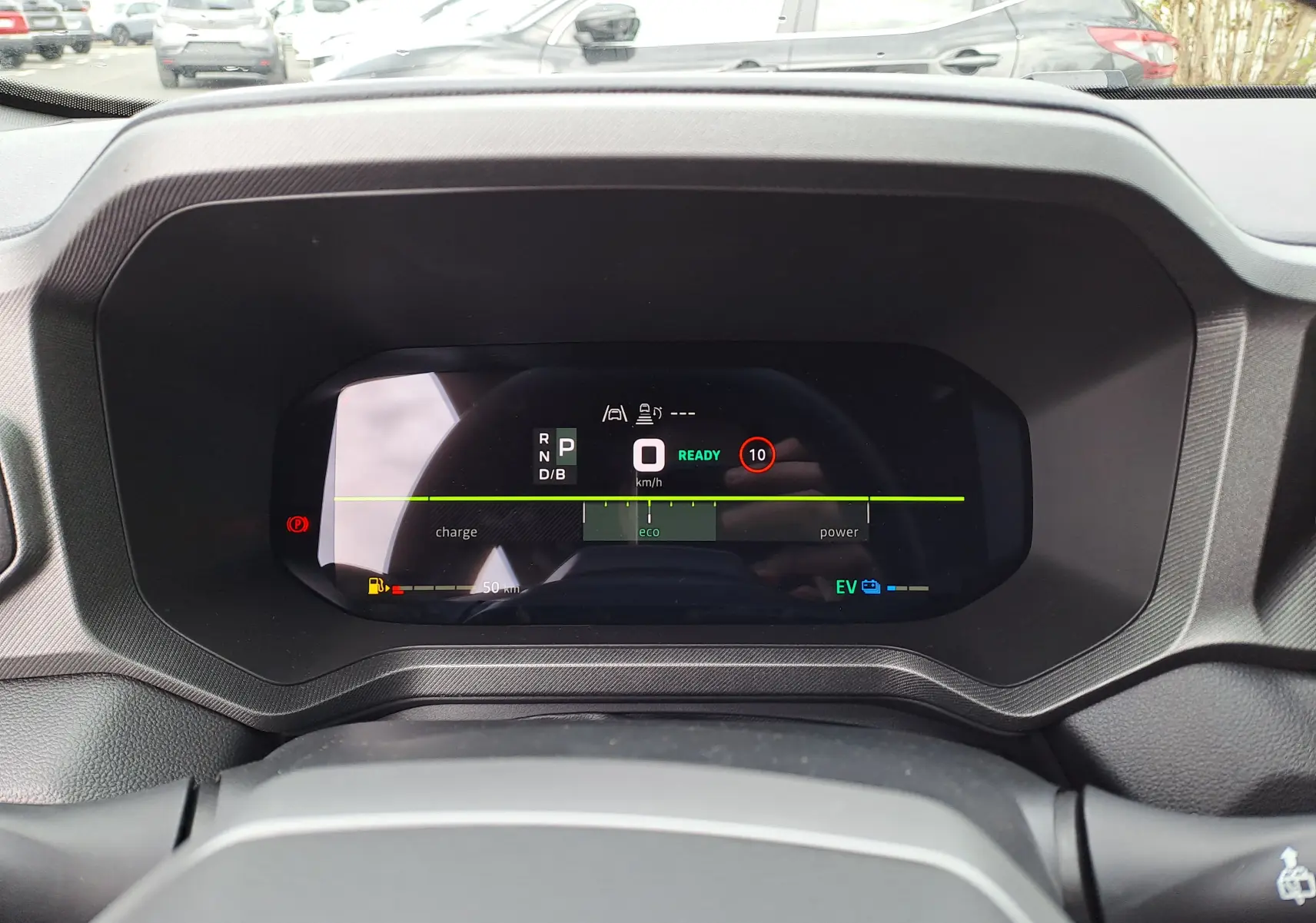 Vue rapprochée du tableau de bord numérique du Dacia Bigster Hybrid 155, affichage en mode éco avec indicateurs de vitesse et énergie.