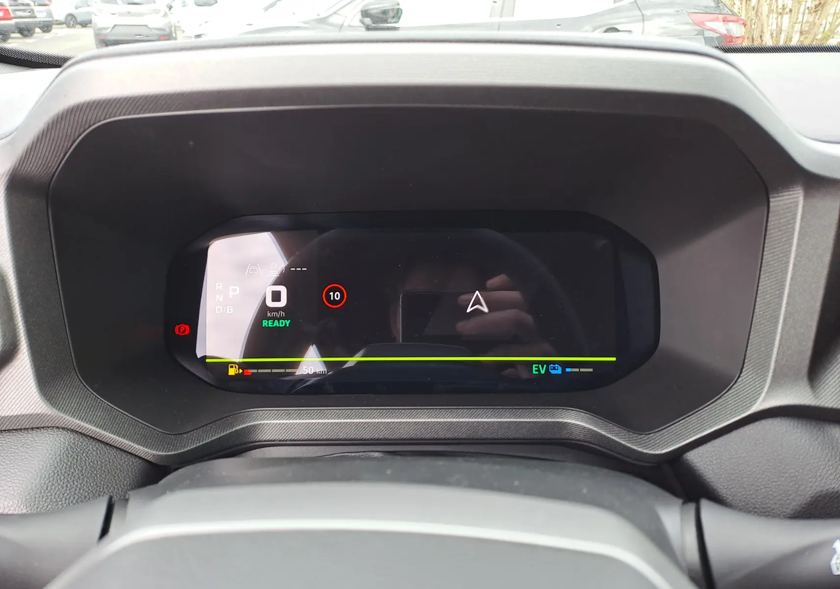Tableau de bord numérique du Dacia Bigster hybride, affichage de la vitesse et navigation, vue frontale intérieure.